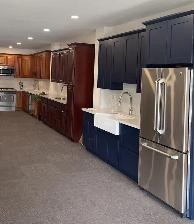 New Again showroom on Mangrove Ave with navy shaker cabinets around a farmhouse sink and cherry cabinet displays